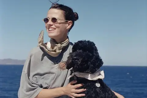 A woman and a dog pose together