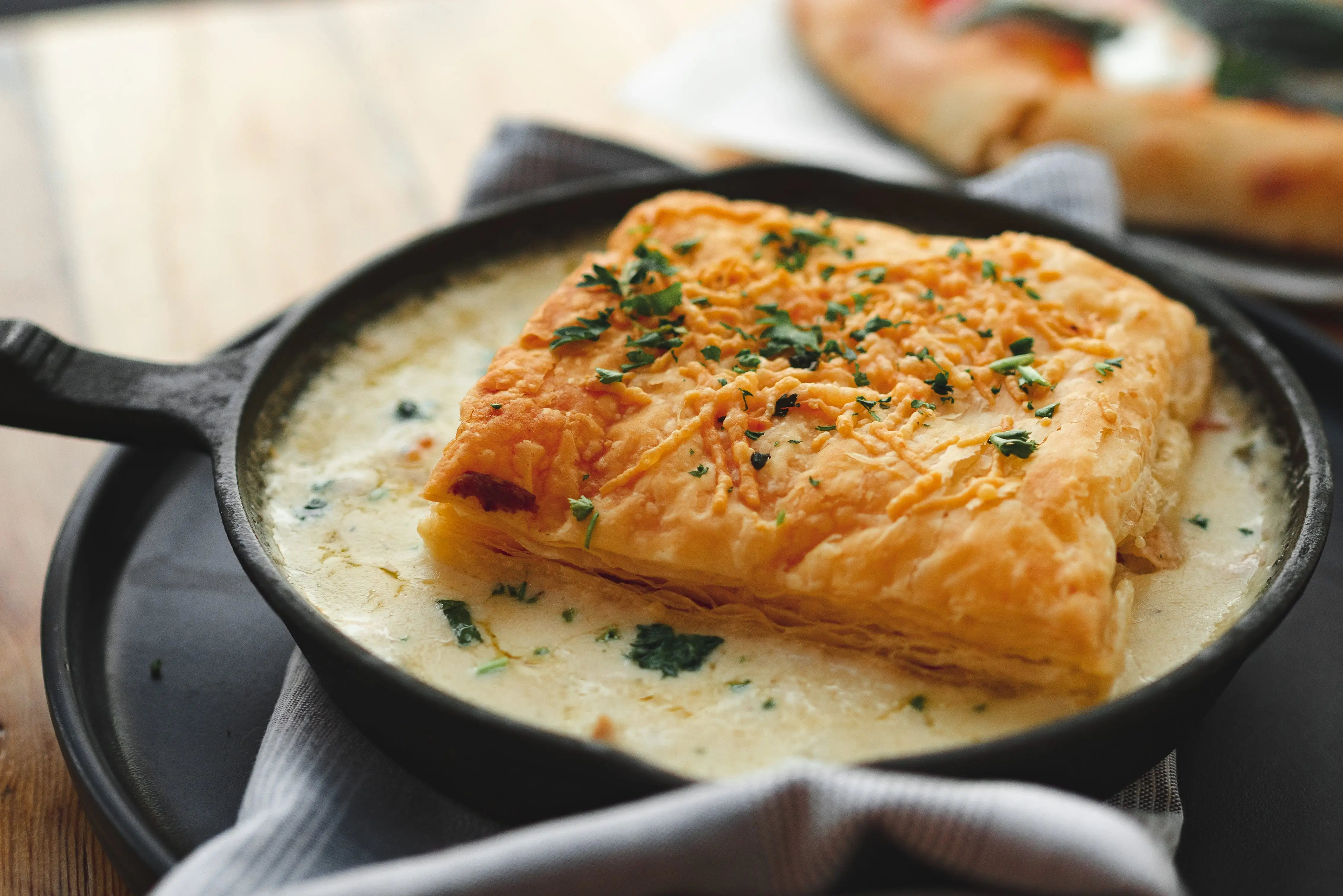 Chicken pot pie in skillet wiht puff pastry crust on top