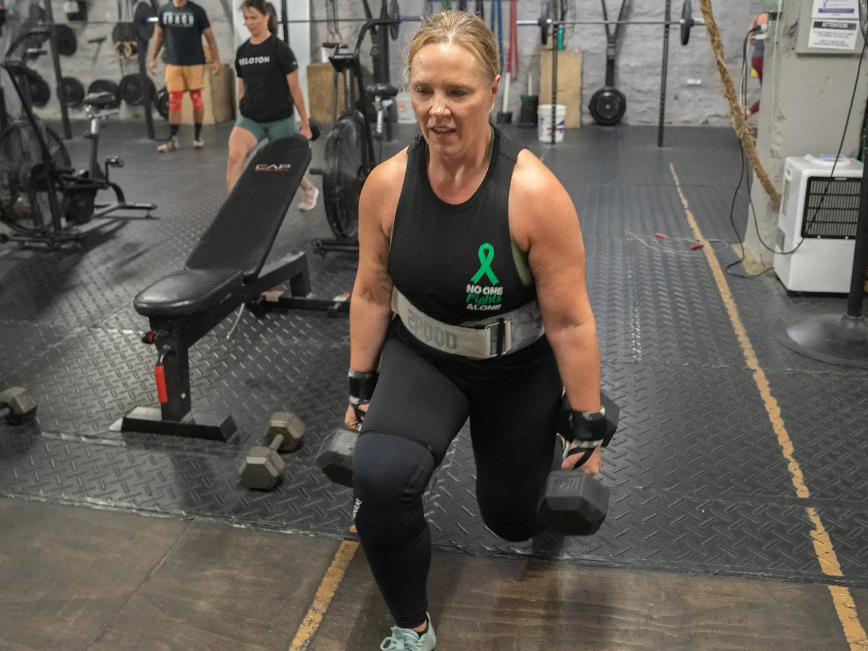 Dr. Shernan Holtan performing weighted lunges in the gym