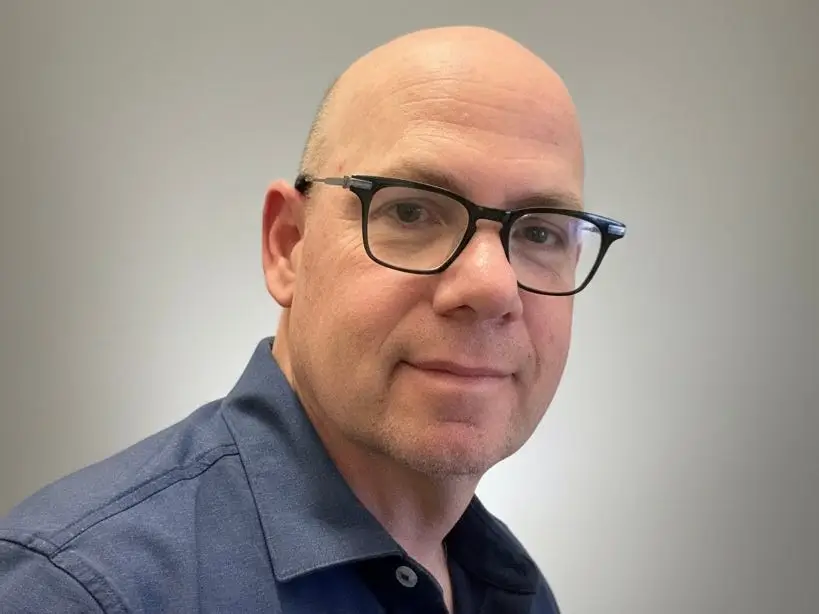 Ari Lehavi in blue button shirt and black glasses