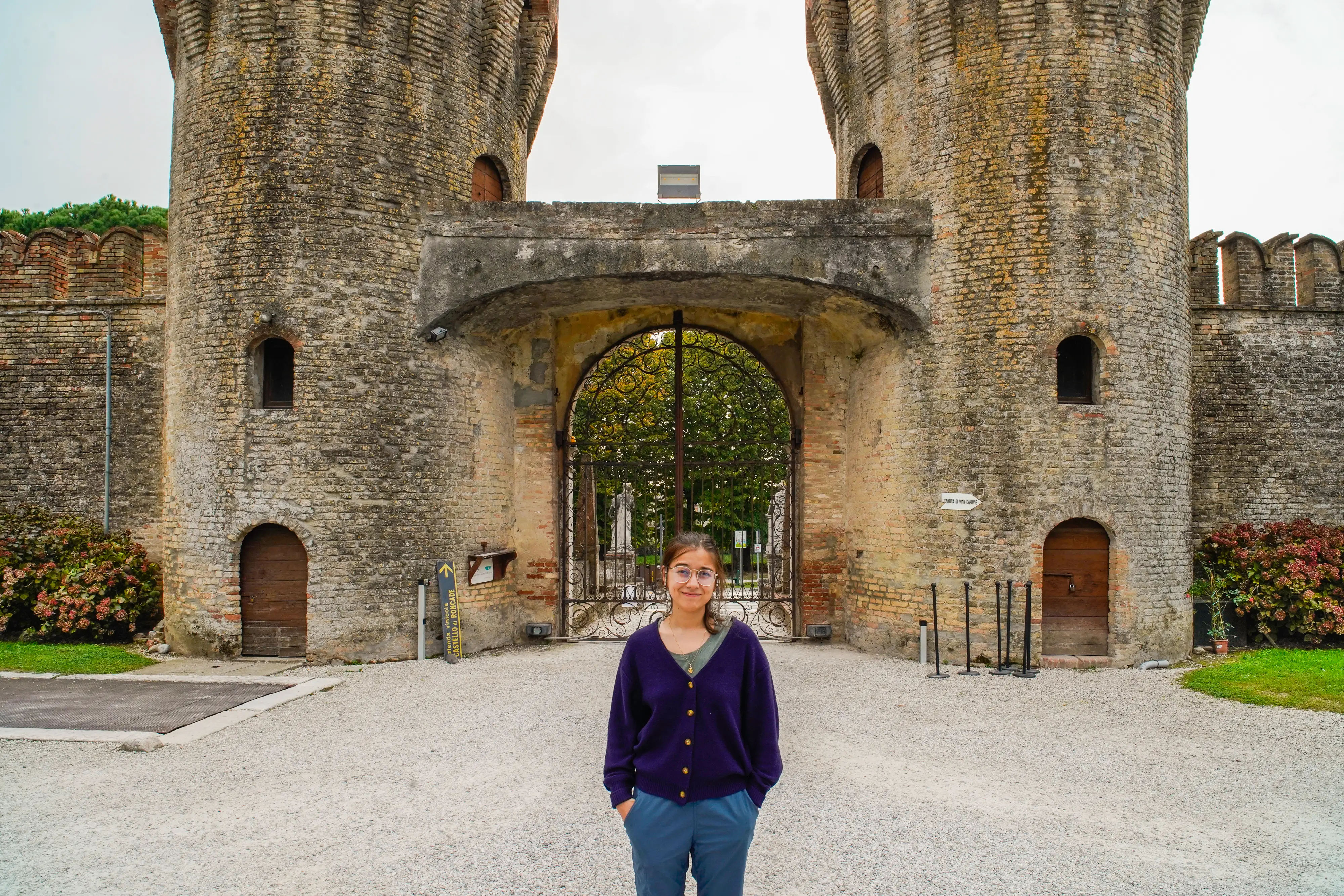 The author stands smiling in front of a castle in Italy