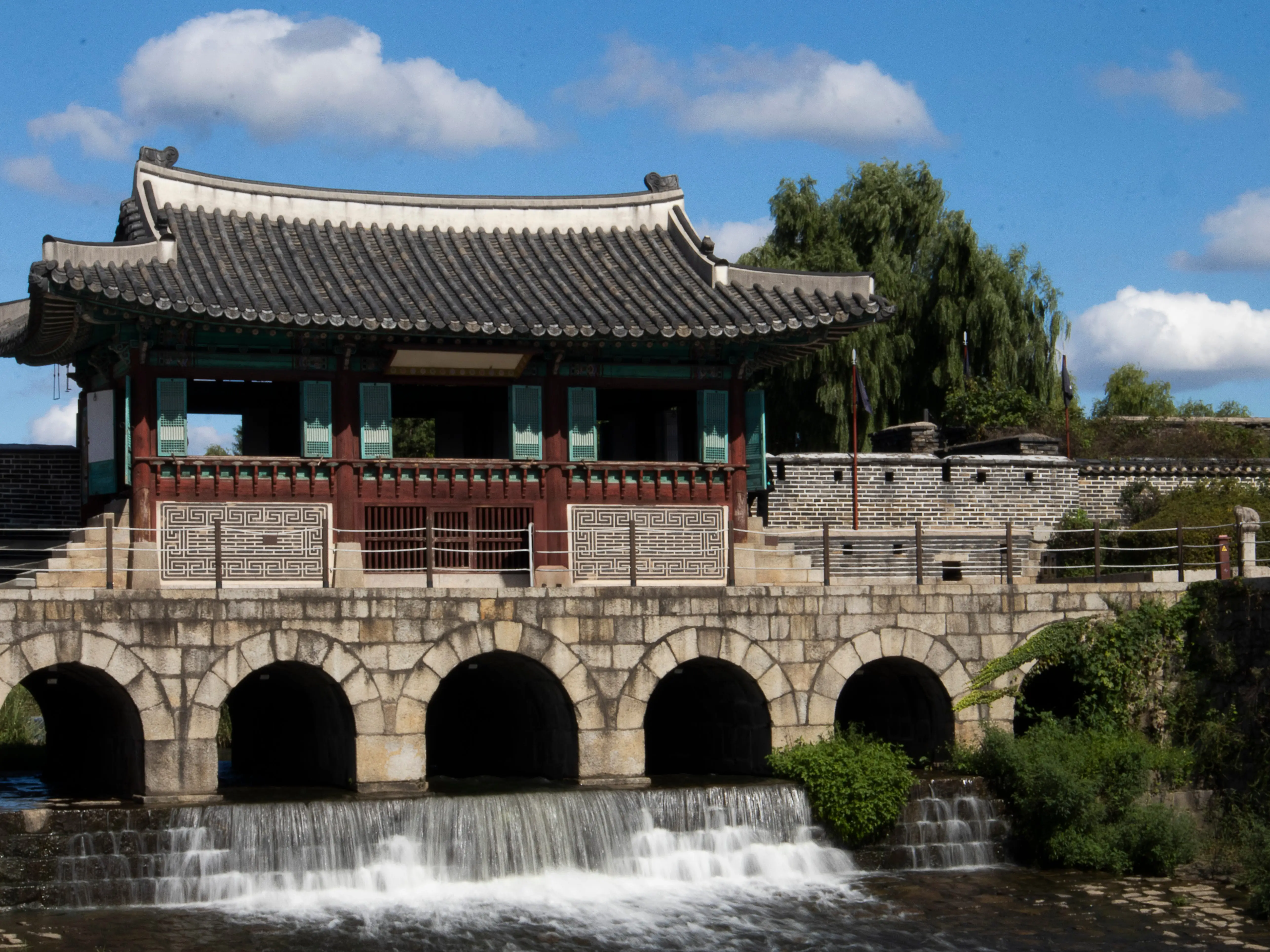 Hwaseong Fortress, and water nearby, on a sunny day in Suwon.
