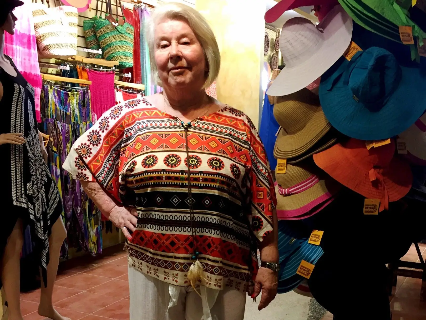 An older woman standing in a clothing store