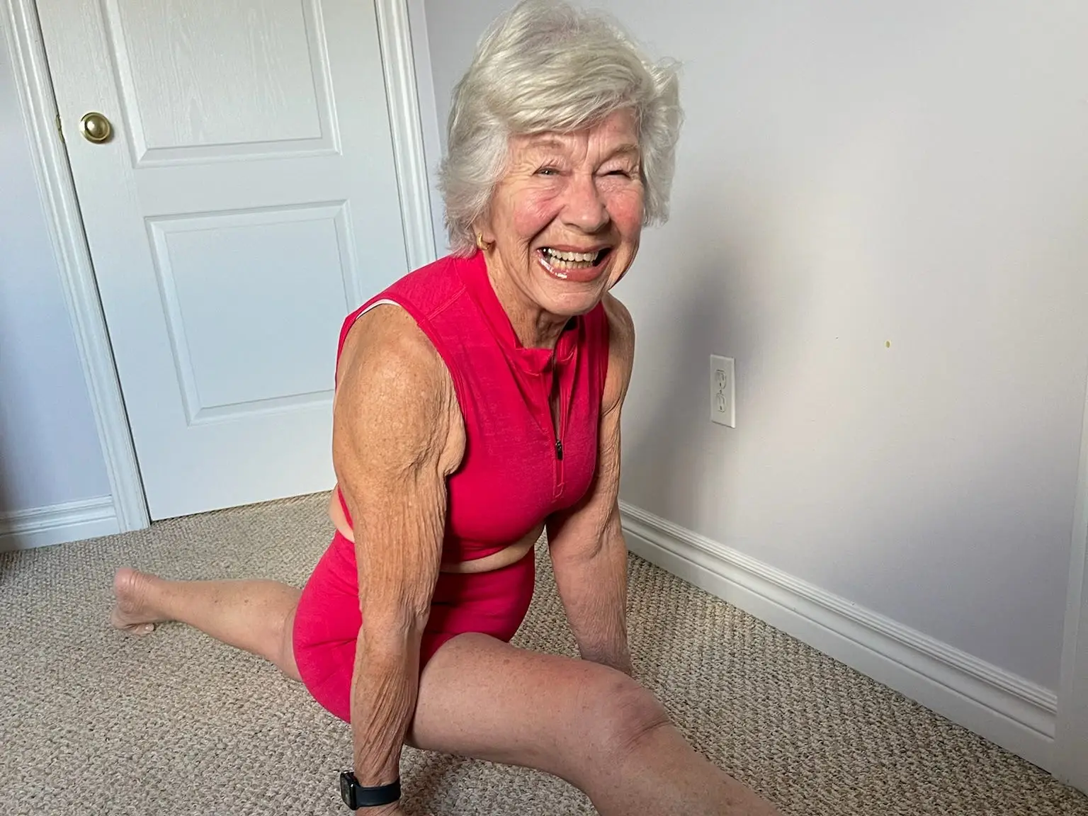 An older woman doing the splits.