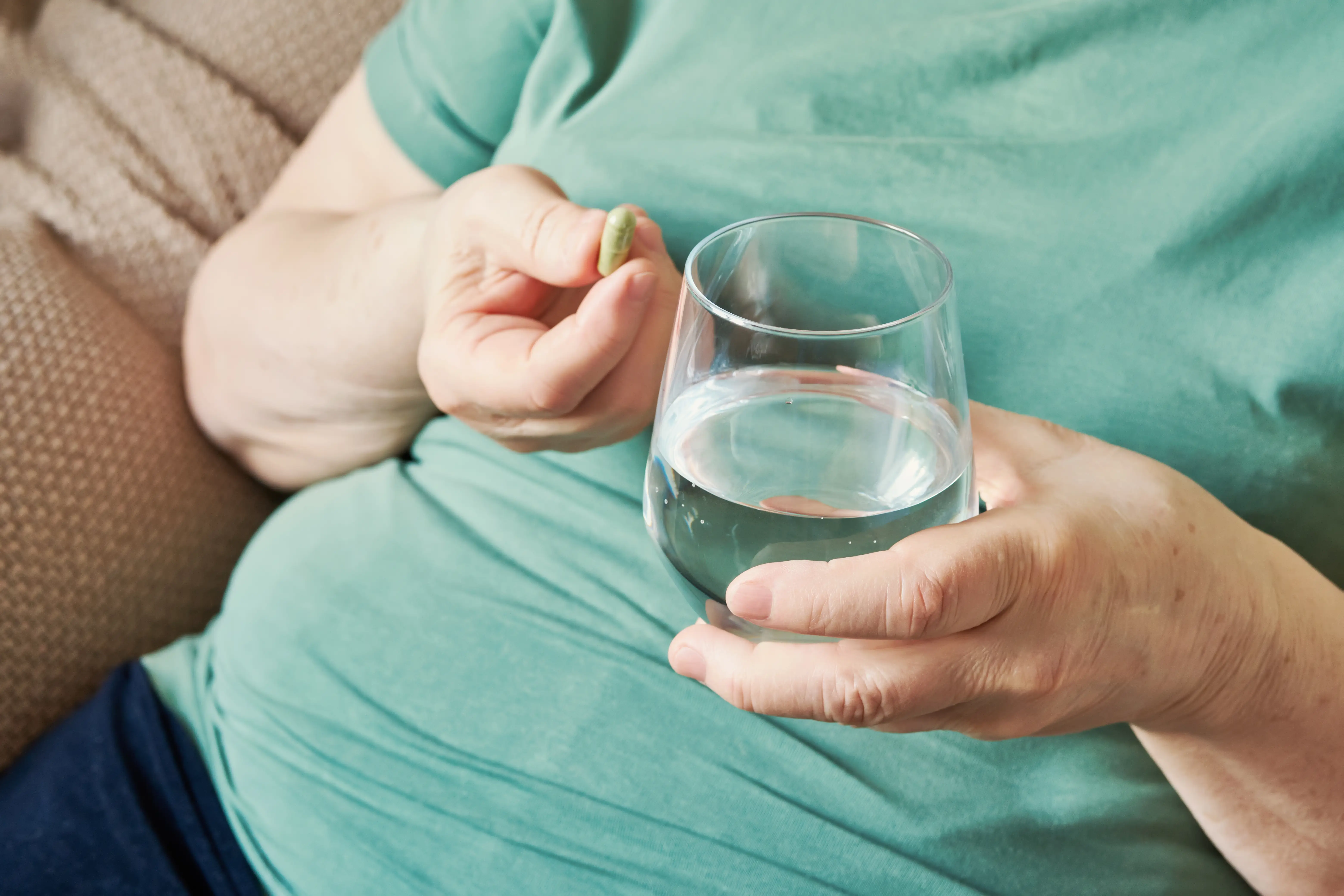 overweight person with a pill and water