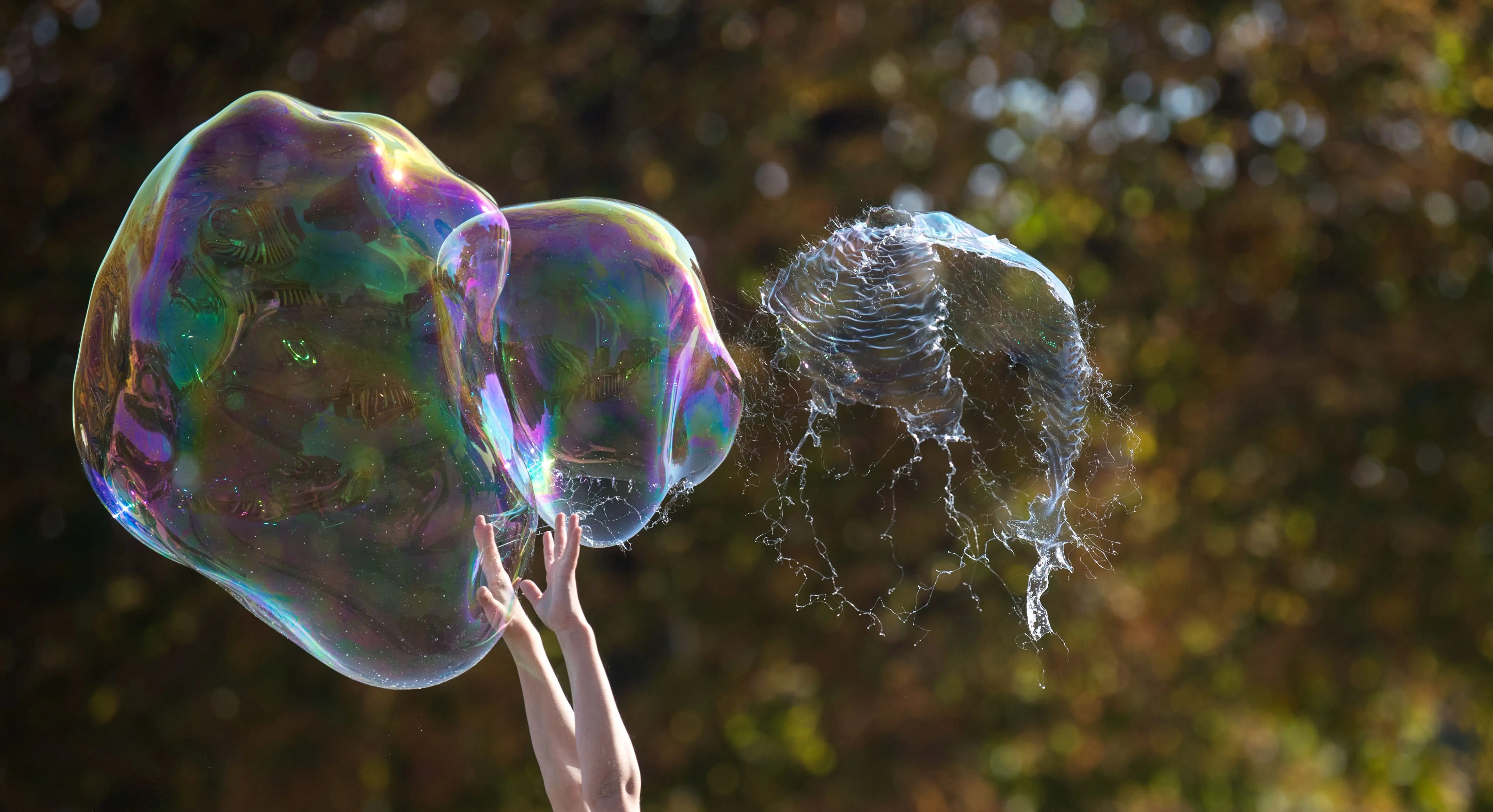 A girl reaches up to burst a large bubble on the Palace Plaza in Stuttgart, Germany, 19 October 2017. Photo: Marijan Murat/dpa (Photo by Marijan Murat/picture alliance via Getty Images)