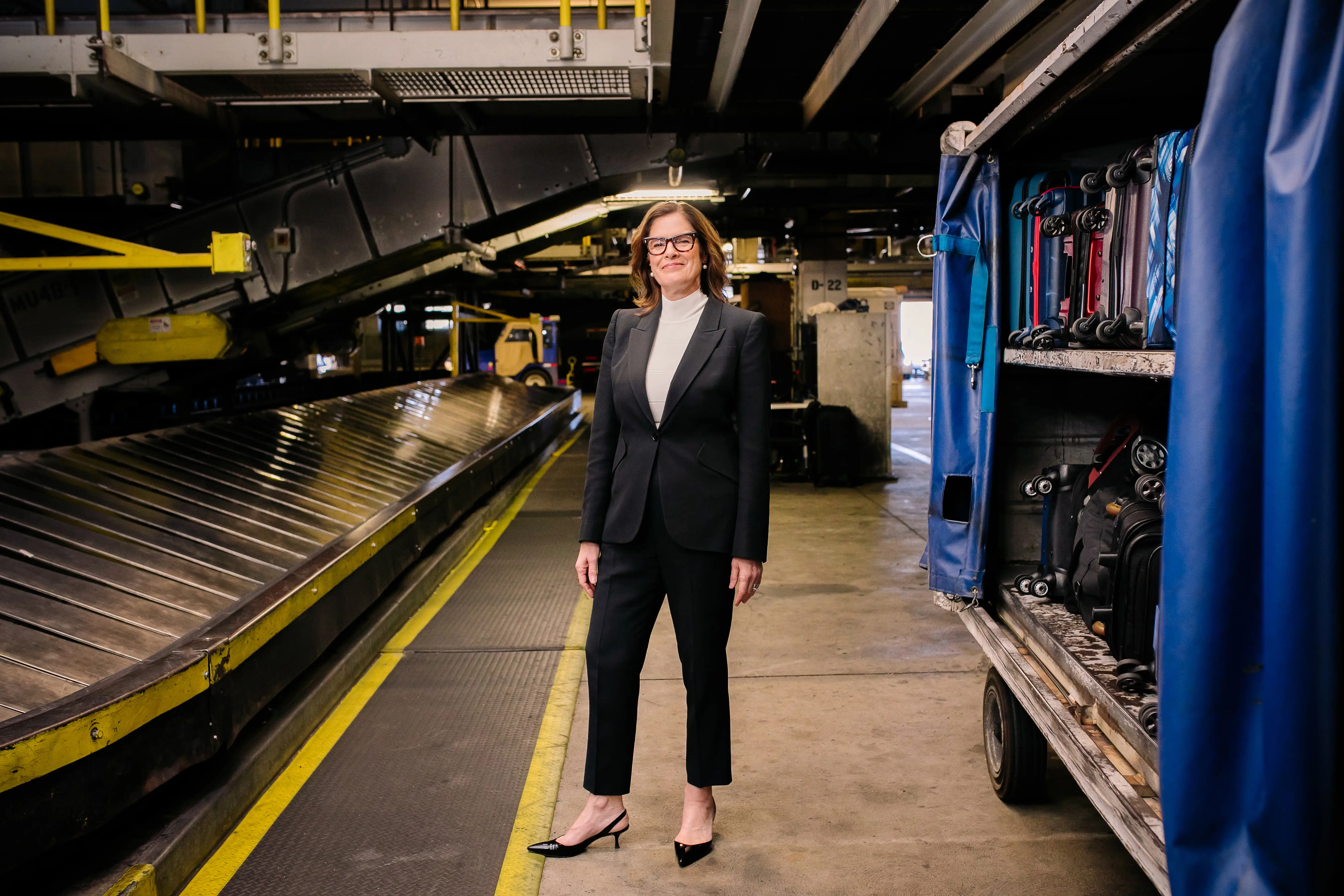 Christina Cassotis standing near a baggage conveyor.