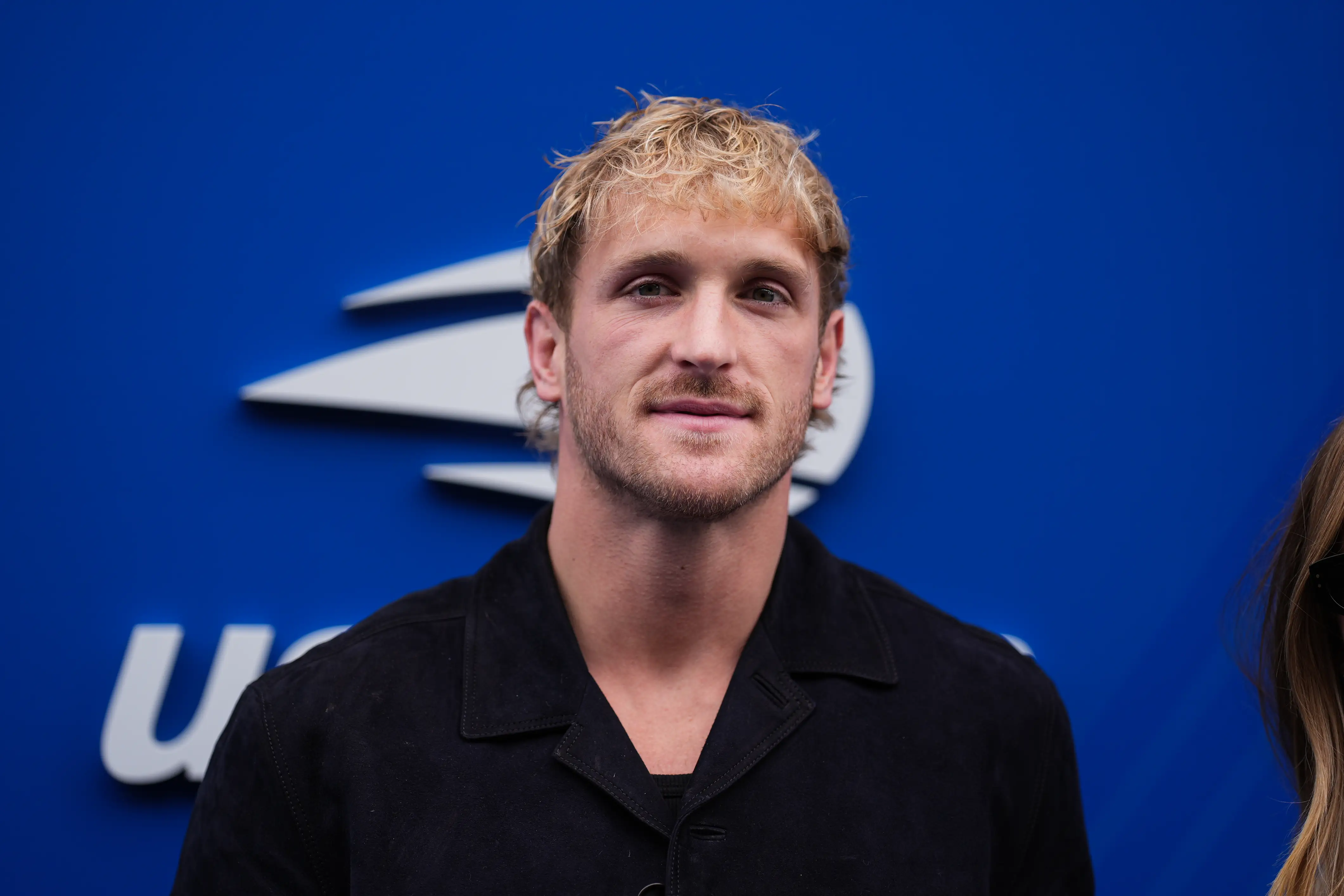 Logan Paul in front of blue background