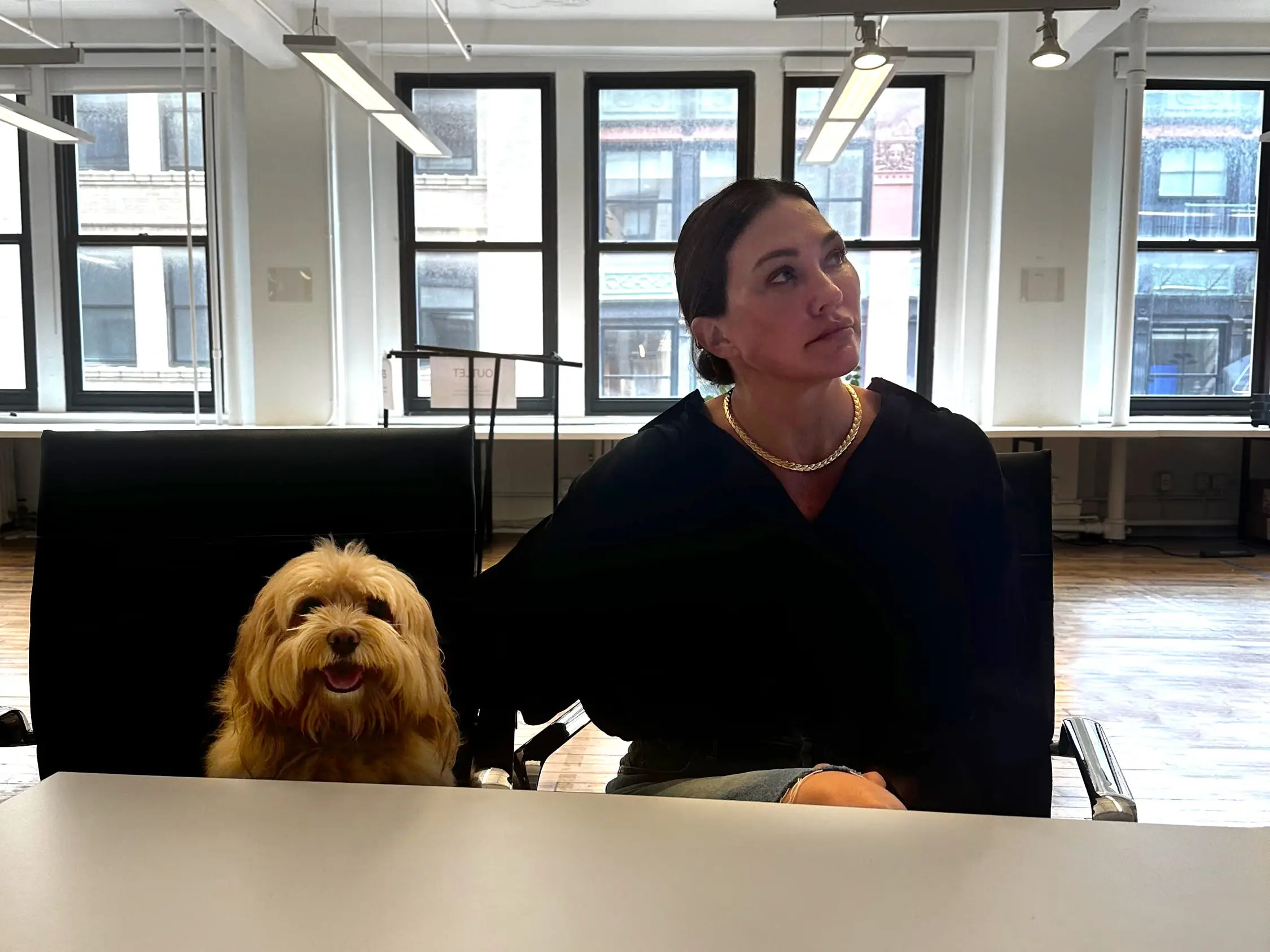 a woman and her dog sitting at a desk