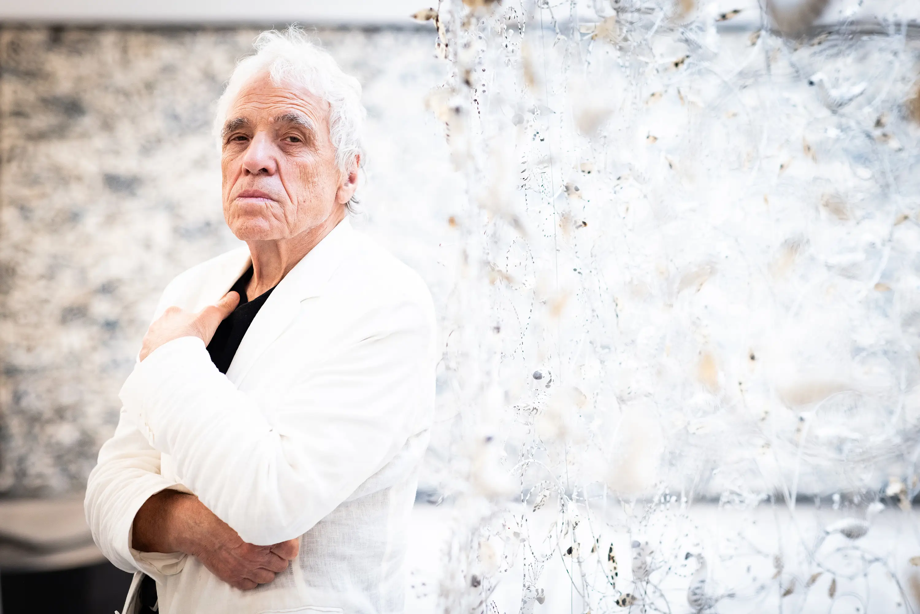 Abel Ferrara in a white coat and black shirt