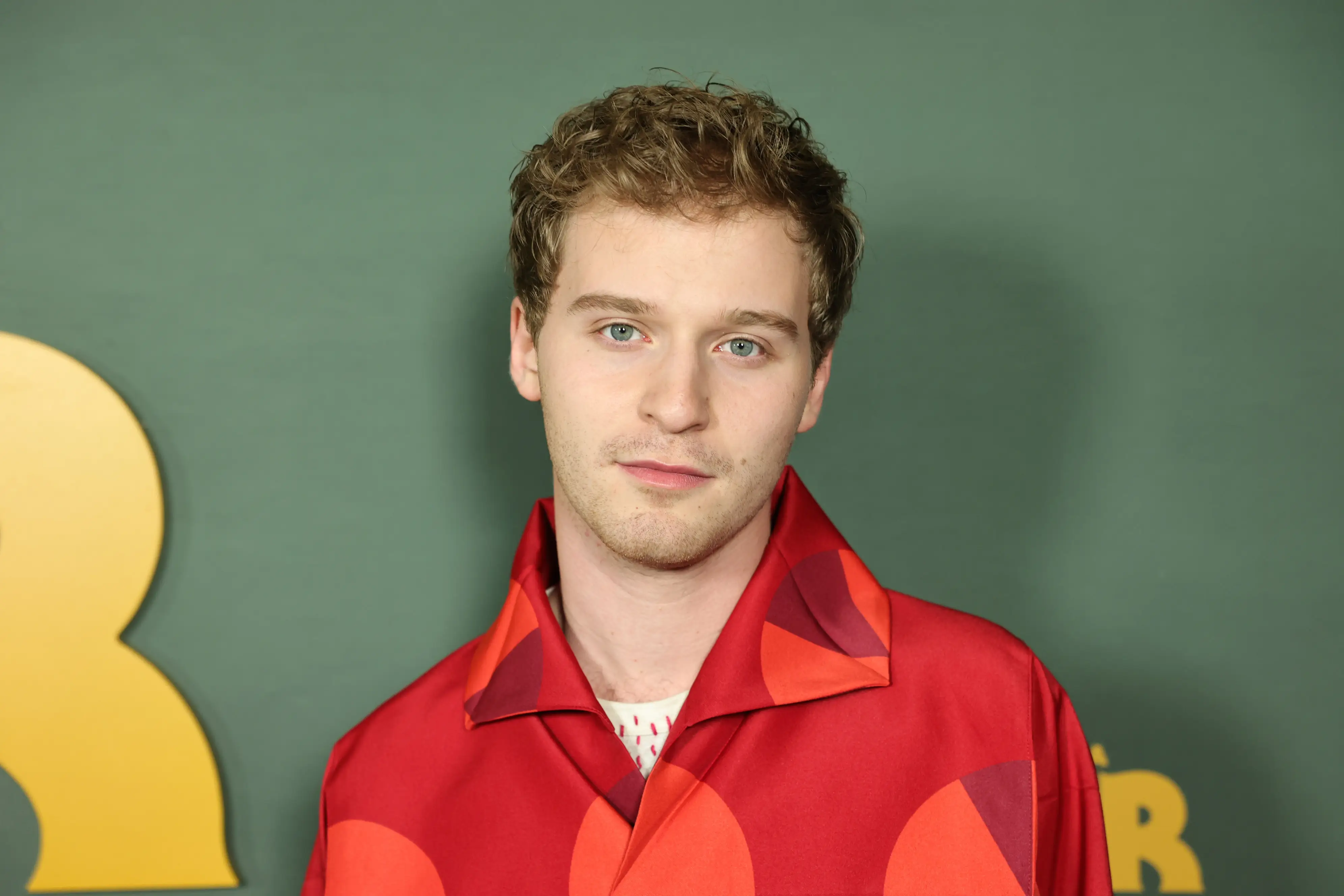 Fred Hechinger in a red shirt