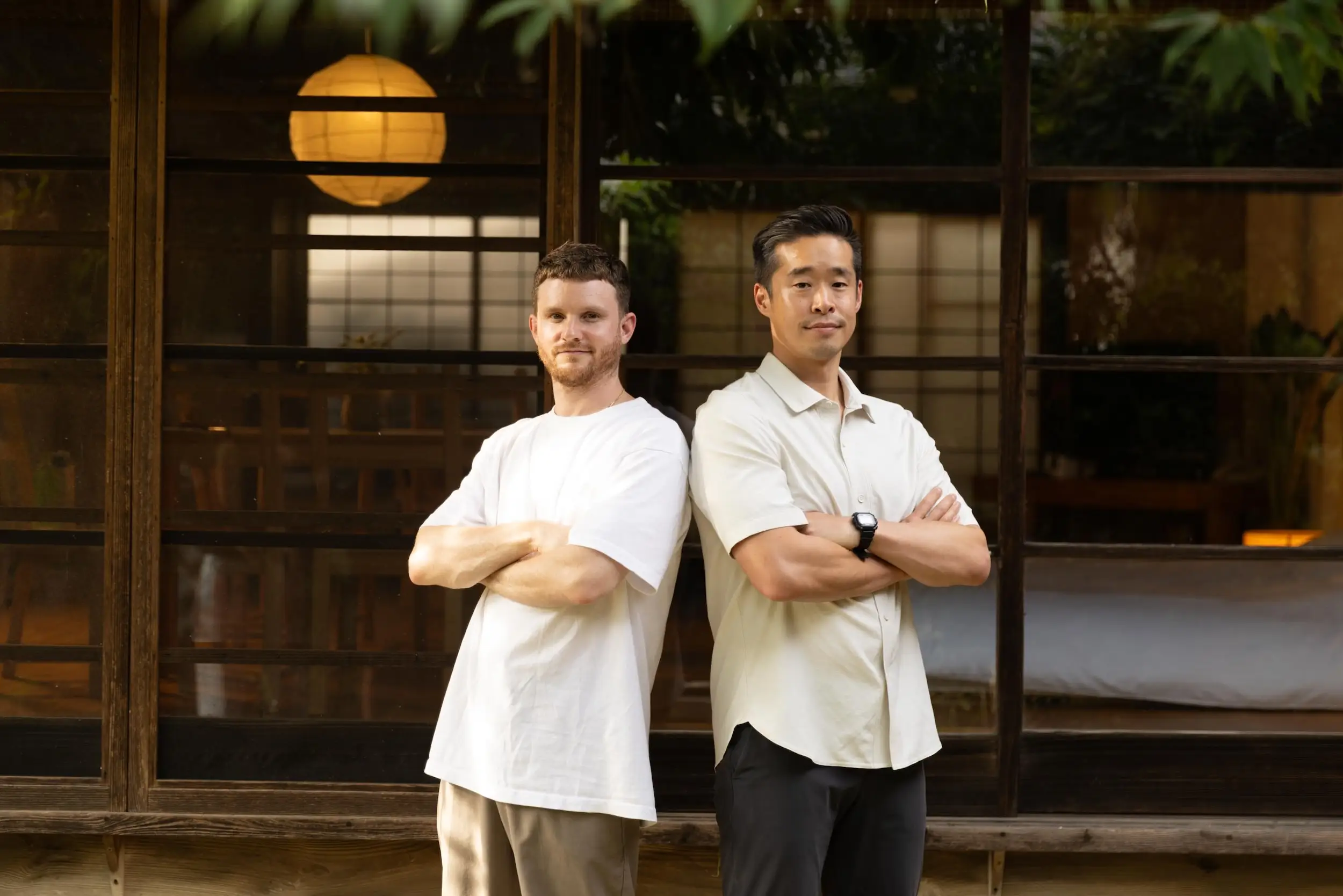 Two men posing back to back.