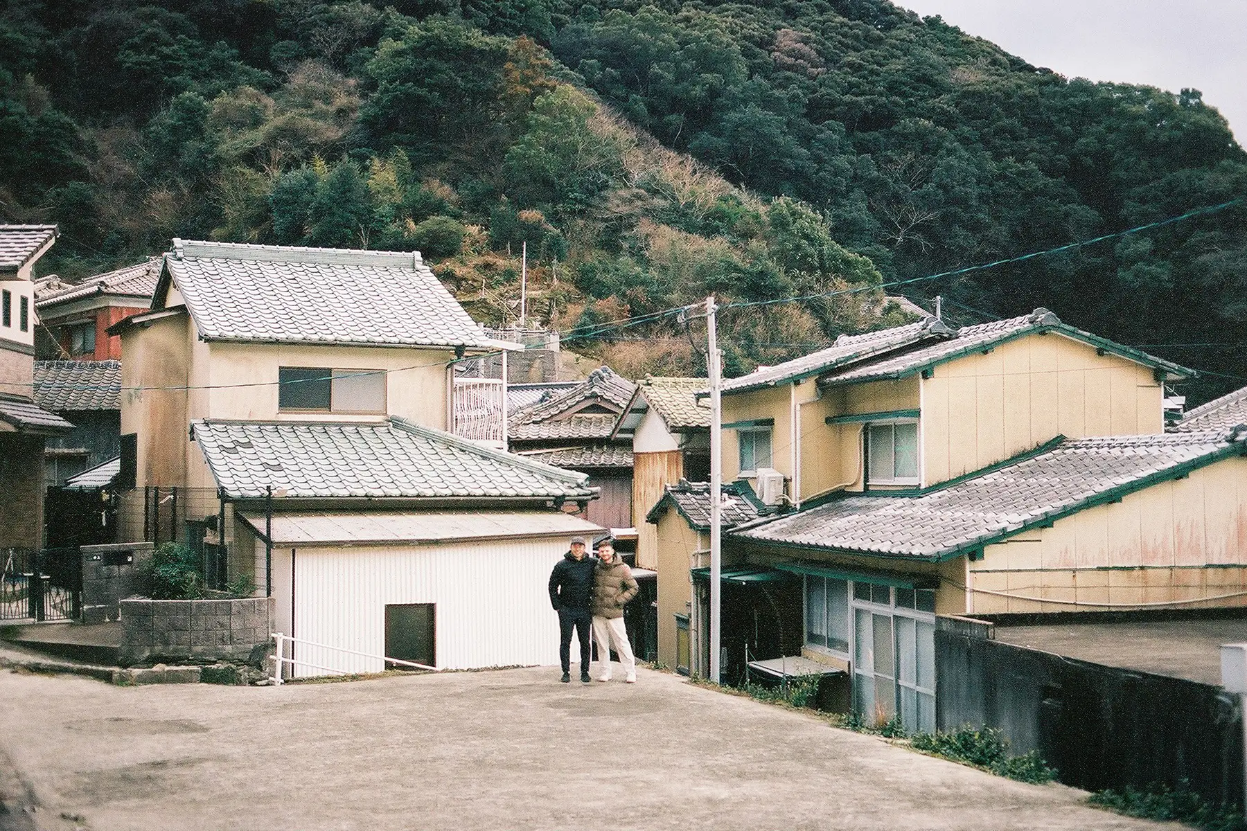 Two men posing in a Japanese city.