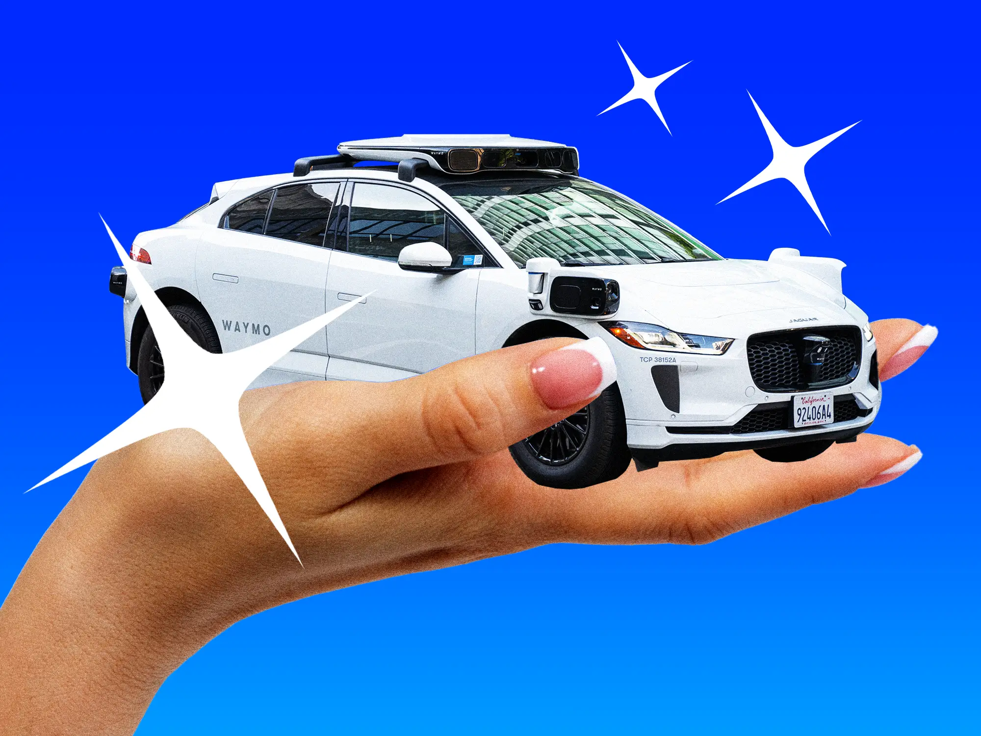 A woman's hand holding a Waymo self driving vehicle