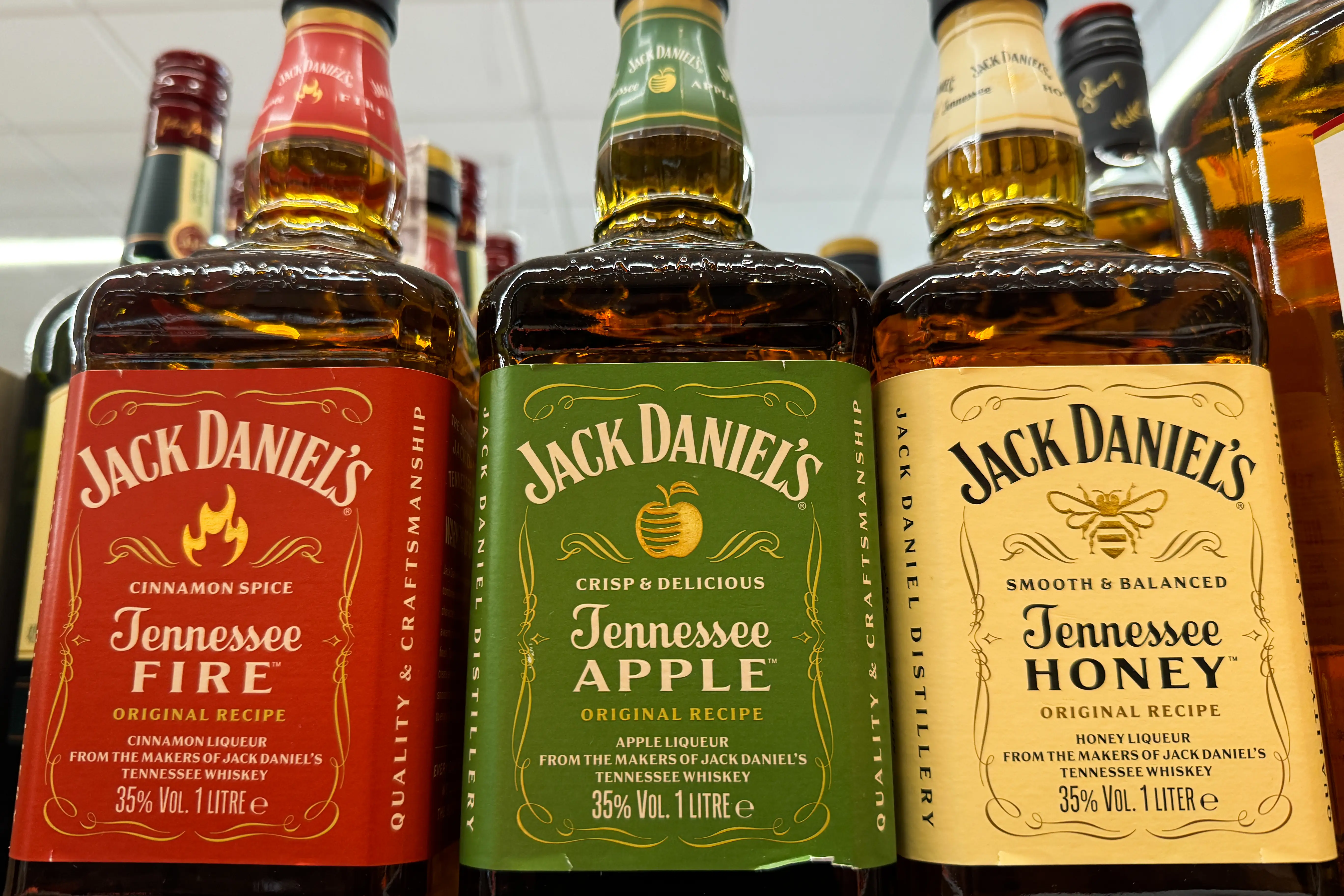 Three flavors of Jack Daniel's lined up on a shelf