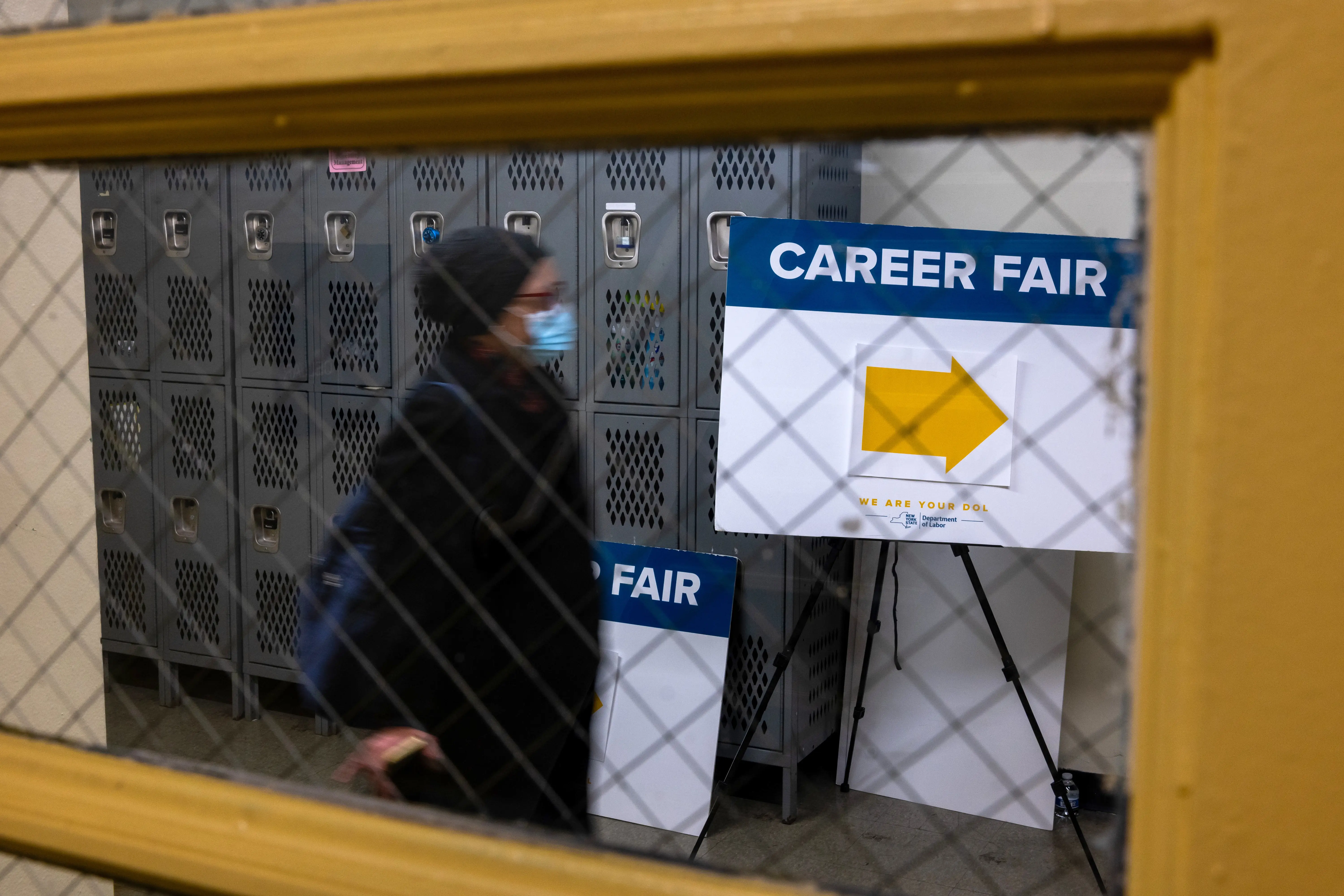 a woman walking into a career fair with a sign that says career fair