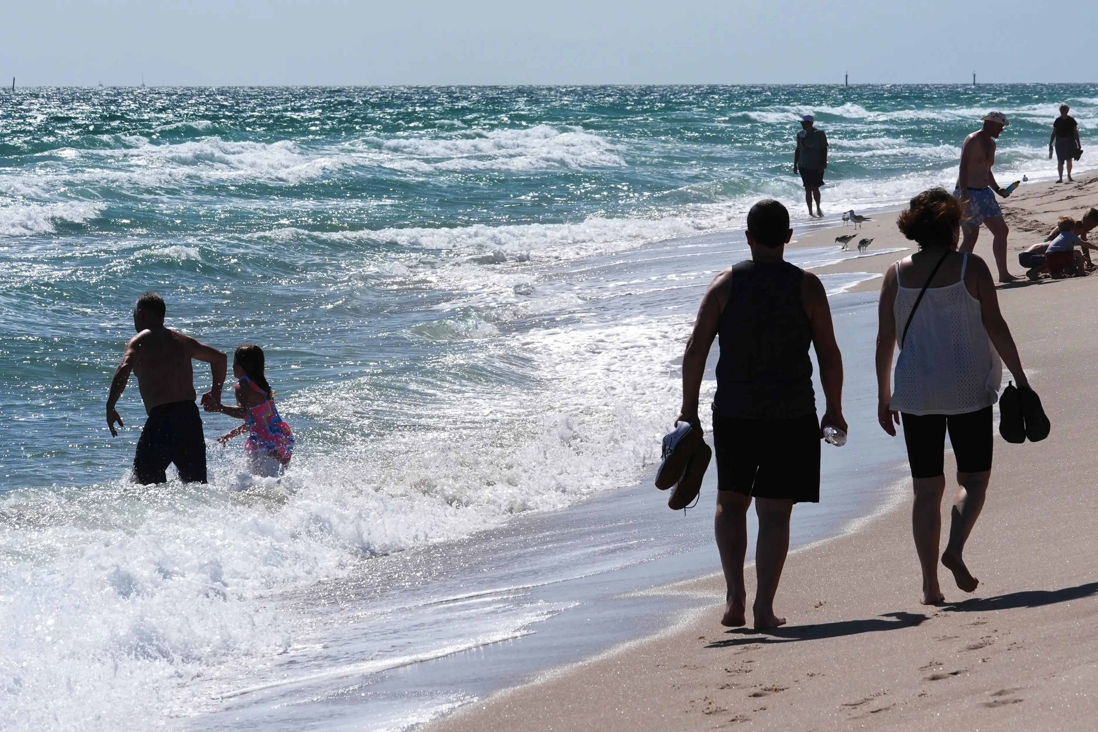 People walk on a Florida beach