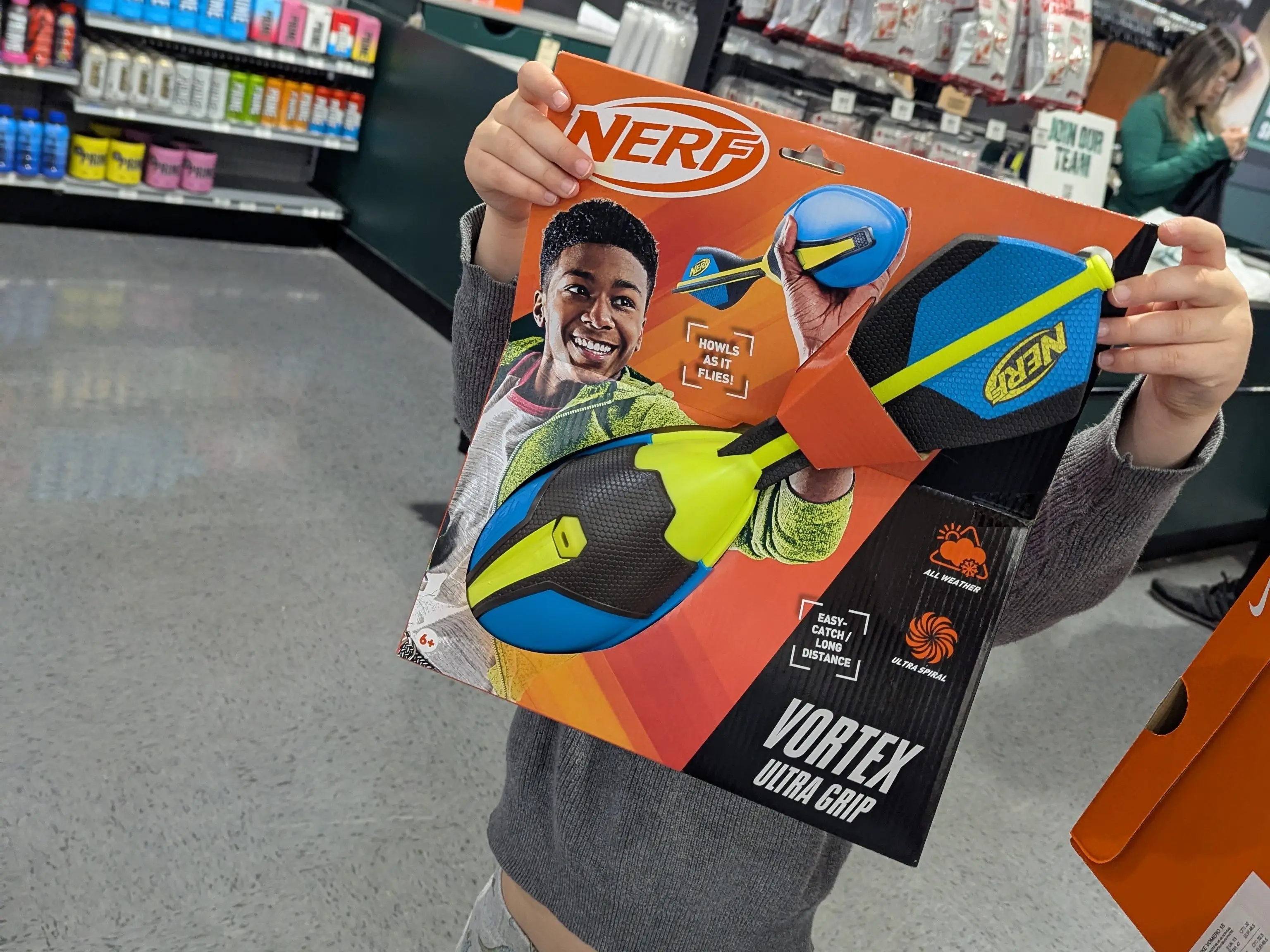 A child holds up a Nerf toy in a store.