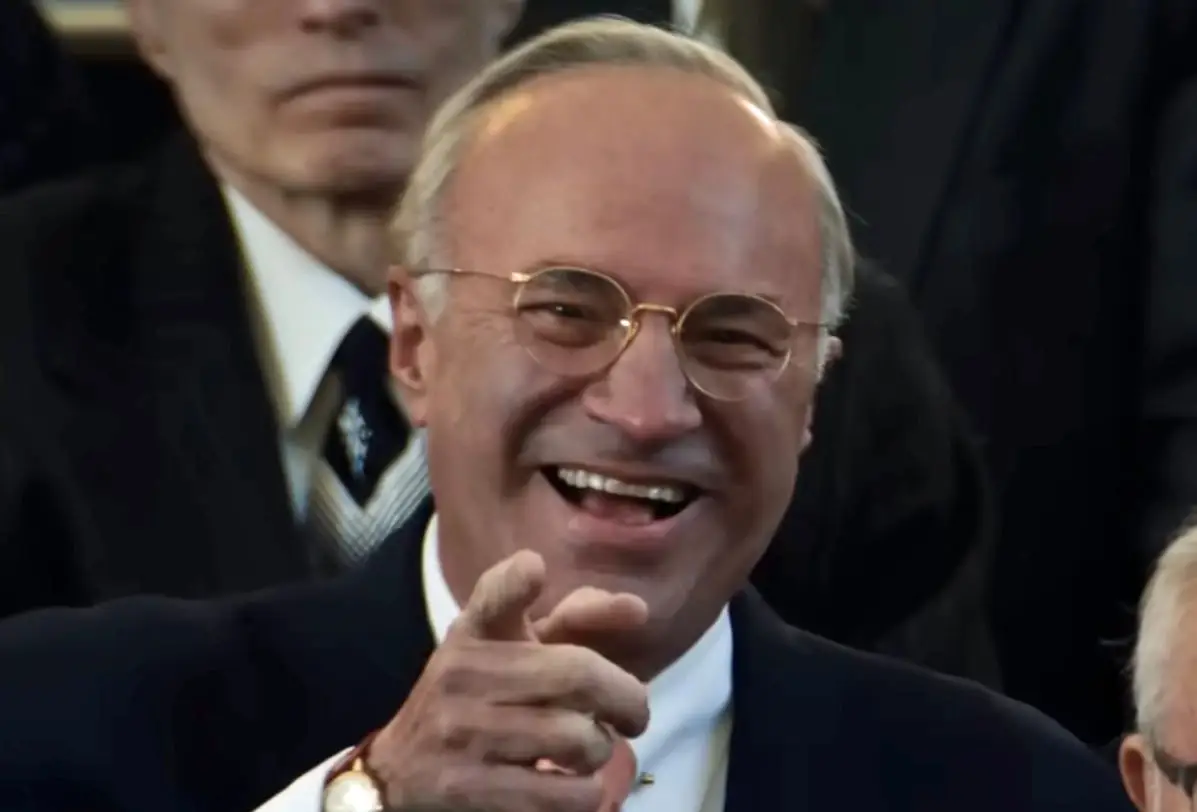 Kevin O'Leary smiling and pointing in a crowd in the Marty Supreme movie