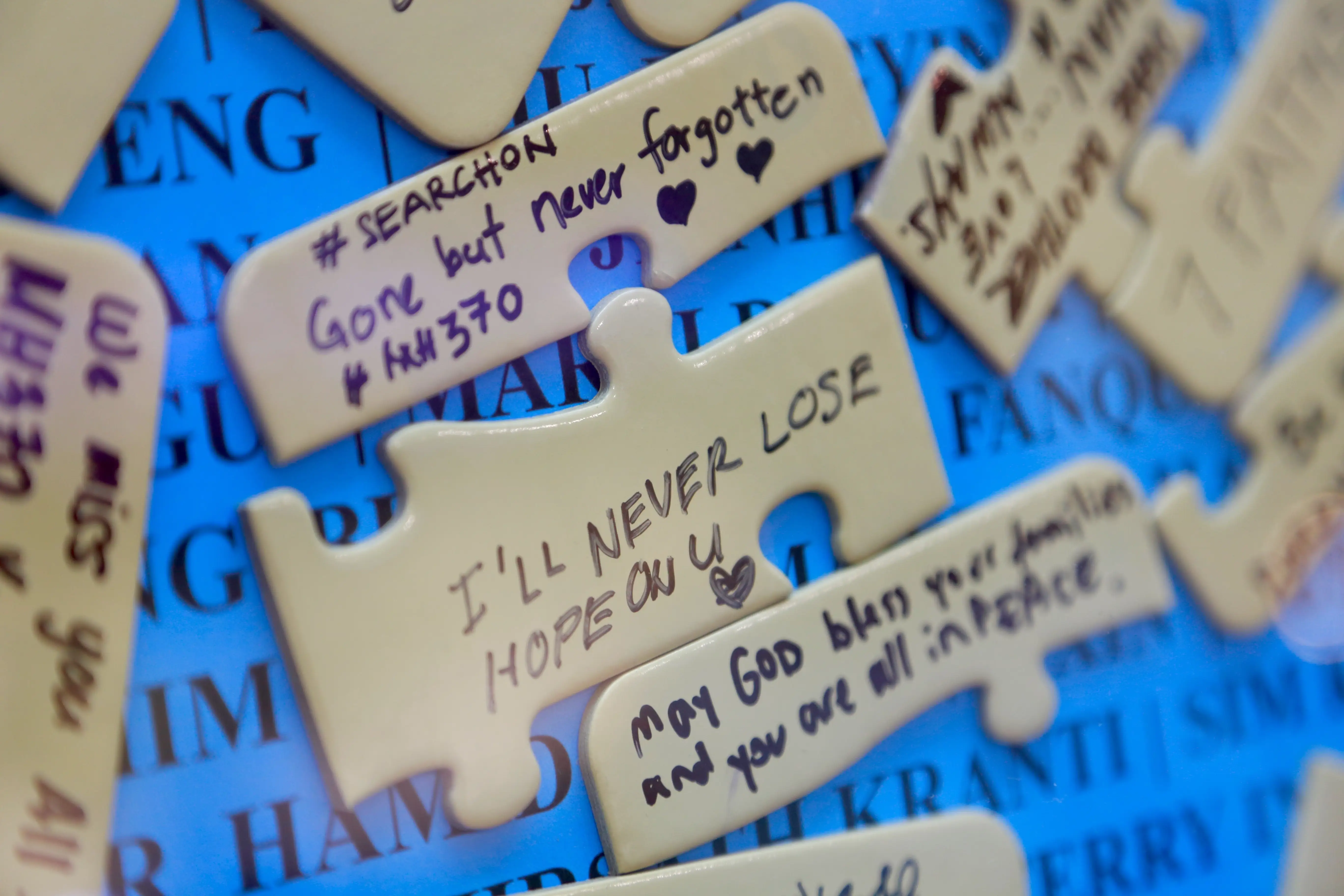 People are writing messages on puzzle-shaped cards at the Day of Remembrance for MH370 in Petaling Jaya, Malaysia, on March 3, 2024.
