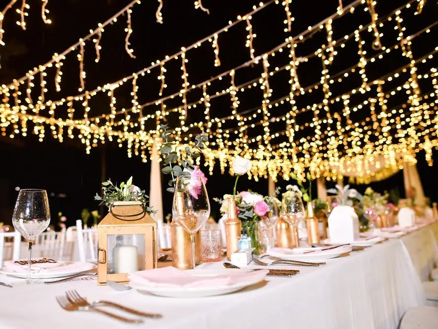String lights hanging above table at wedding