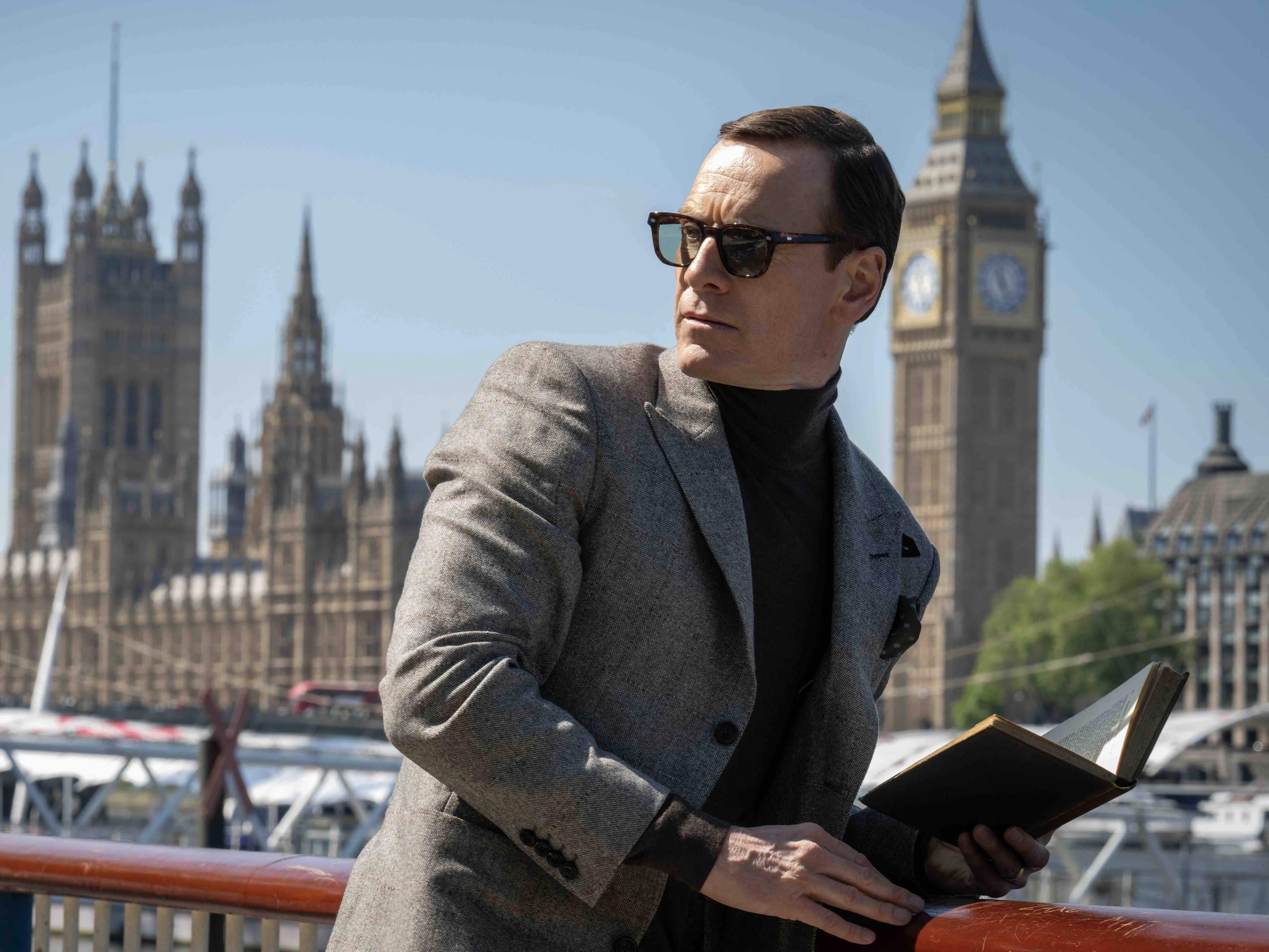 Michael Fassbender holding a book wearing sunglasses