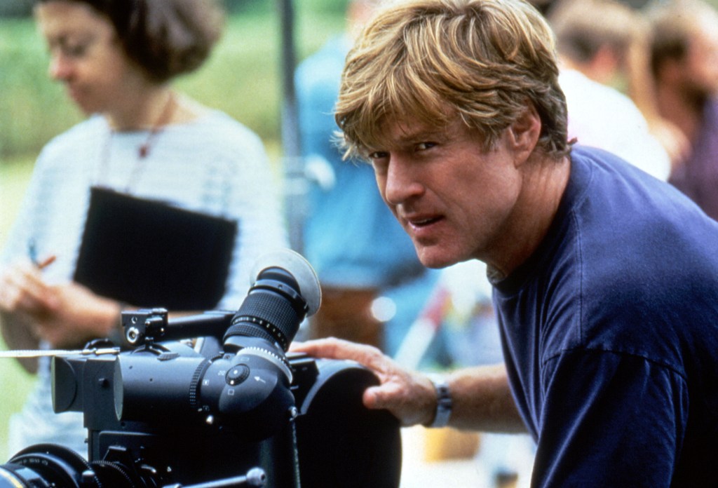 Robert Redford behind a film camera.