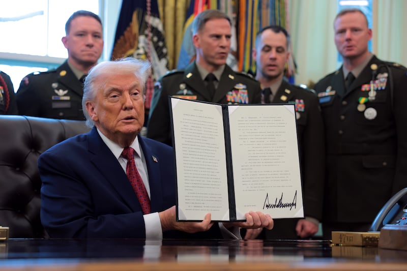 President Donald Trump holds up an executive order he signed to classify fentanyl a weapon of mass destruction during a ceremony to present the Mexican Border Defense Medal in the Oval Office of the White House on December 15, 2025.