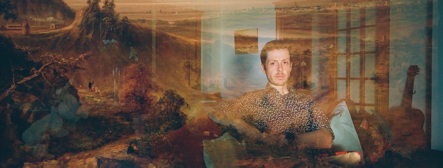 photo with a double exposure, one of a man sitting in his living room next to a guitar with a hazy overlay of a 17th-century landscape painting
