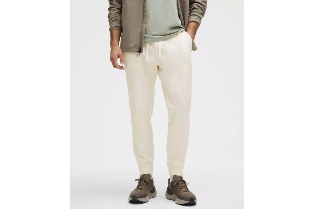 A man wearing white joggers and a jacket.