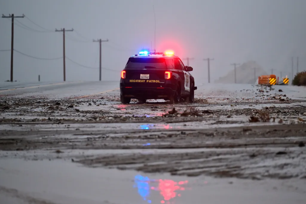 A California Highway Patrol officer drives along California State Route 138 through mud Wednesday, Dec. 24, 2025, near Wrightwood, Calif.