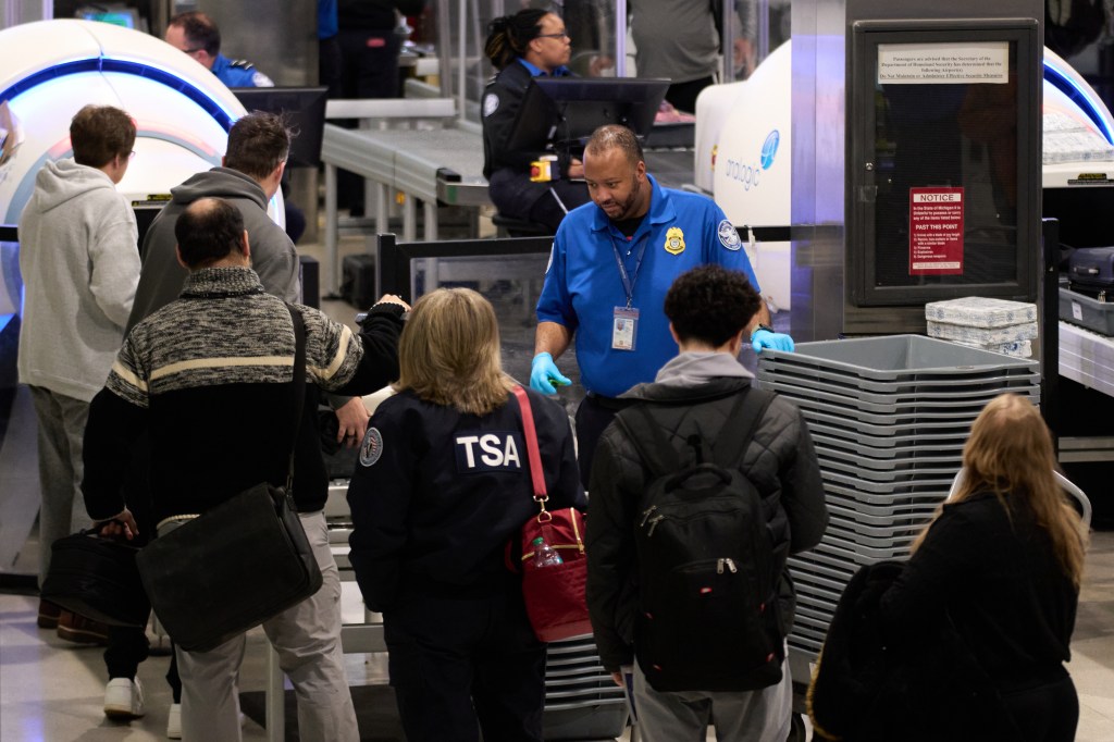 Travelers wait at a TSA security checkpoint at Detroit Metropolitan Wayne County Airport Sunday, Nov. 30, 2025, in Romulus, Mich.