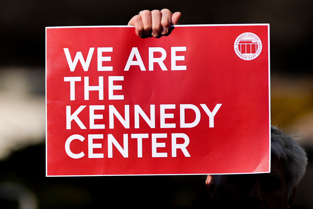 A demonstrator holds a sign during a protest, after a Trump-appointed board voted to add President Donald Trump's name to the John F. Kennedy Memorial Center for the Performing Arts, Saturday, Dec. 20, 2025, in Washington. 