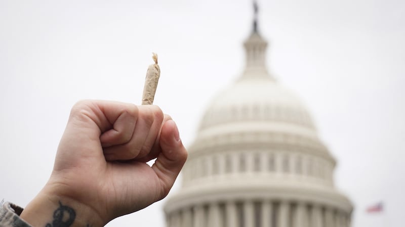 A pro-cannabis activist holds up a marijuana cigarette.