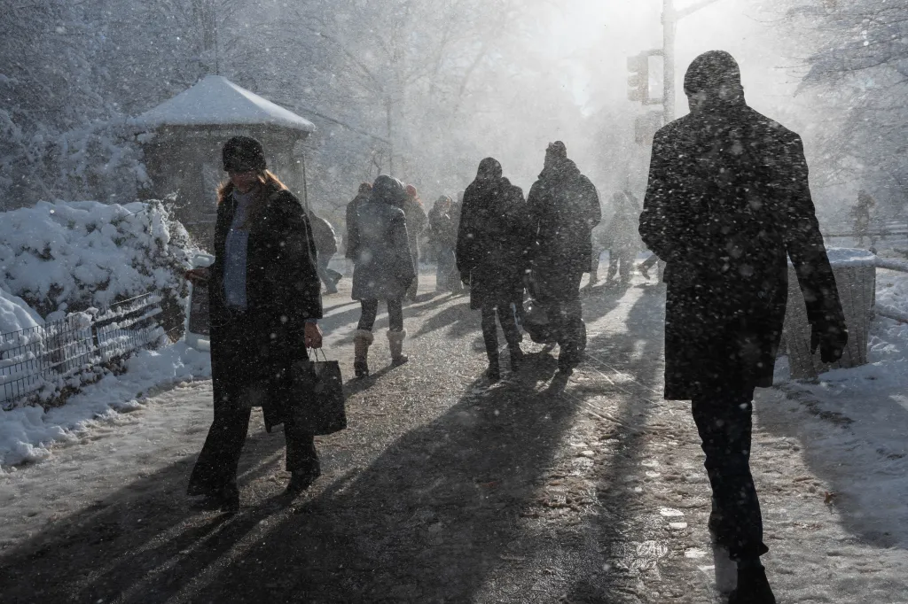 People walking on a snowy path in Manhattan during a snowstorm.