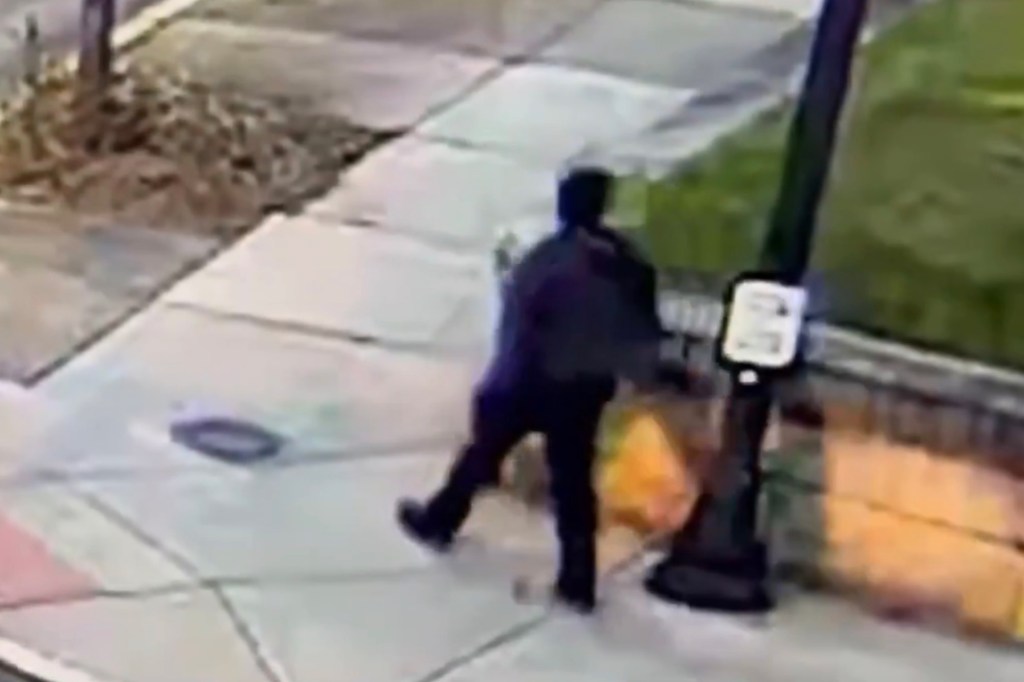 A monitor shows security camera footage of what police say is the Brown University shooting suspect walking along Hope Street after leaving the scene of shooting