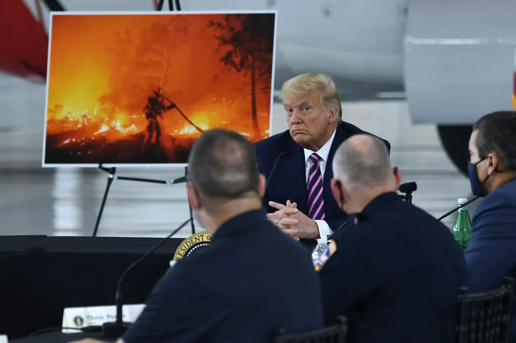 President Donald Trump(C) listens to California Governor Gavin Newsom(D-CA) at Sacramento McClellan Airport in McClellan Park, California on September 14, 2020 during a briefing on wildfires.