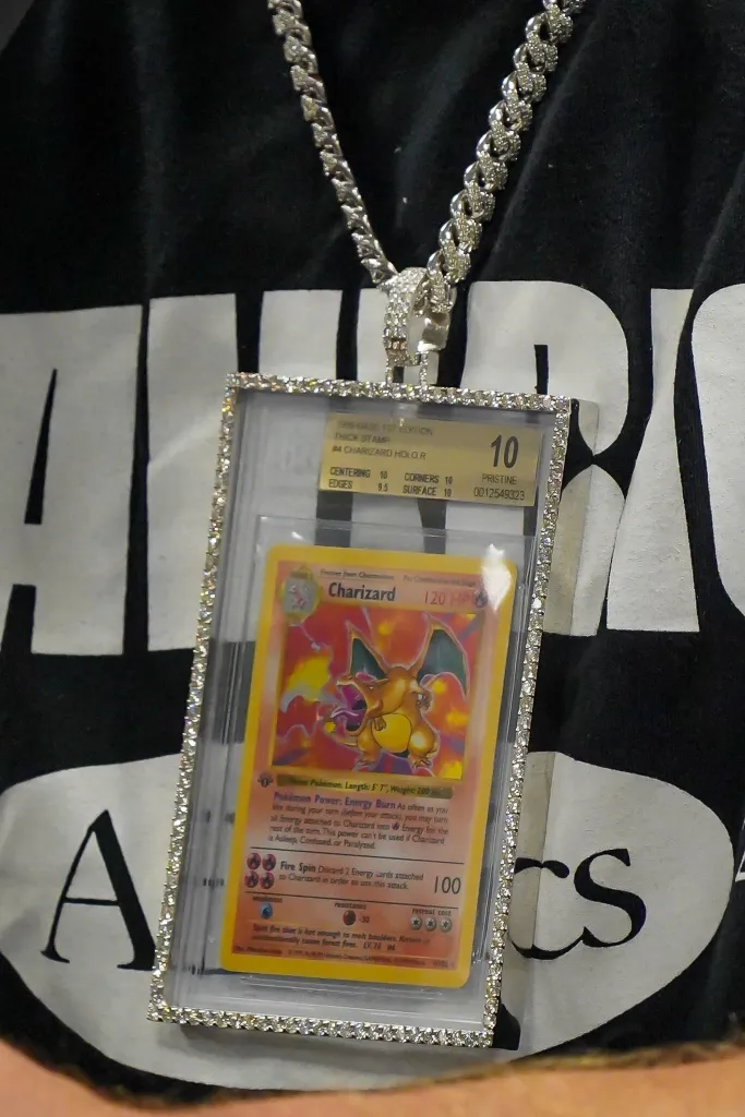 Close-up of a necklace with a Charizard Pokemon card in a diamond-encrusted pendant.