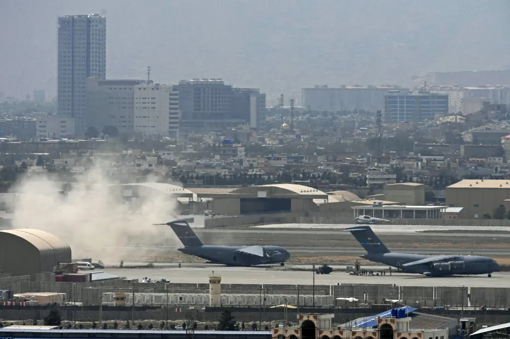 US soldiers stand on the tarmac as an US Air Force aircraft (L) prepares for take off from the airport in Kabul on Aug. 30, 2021.