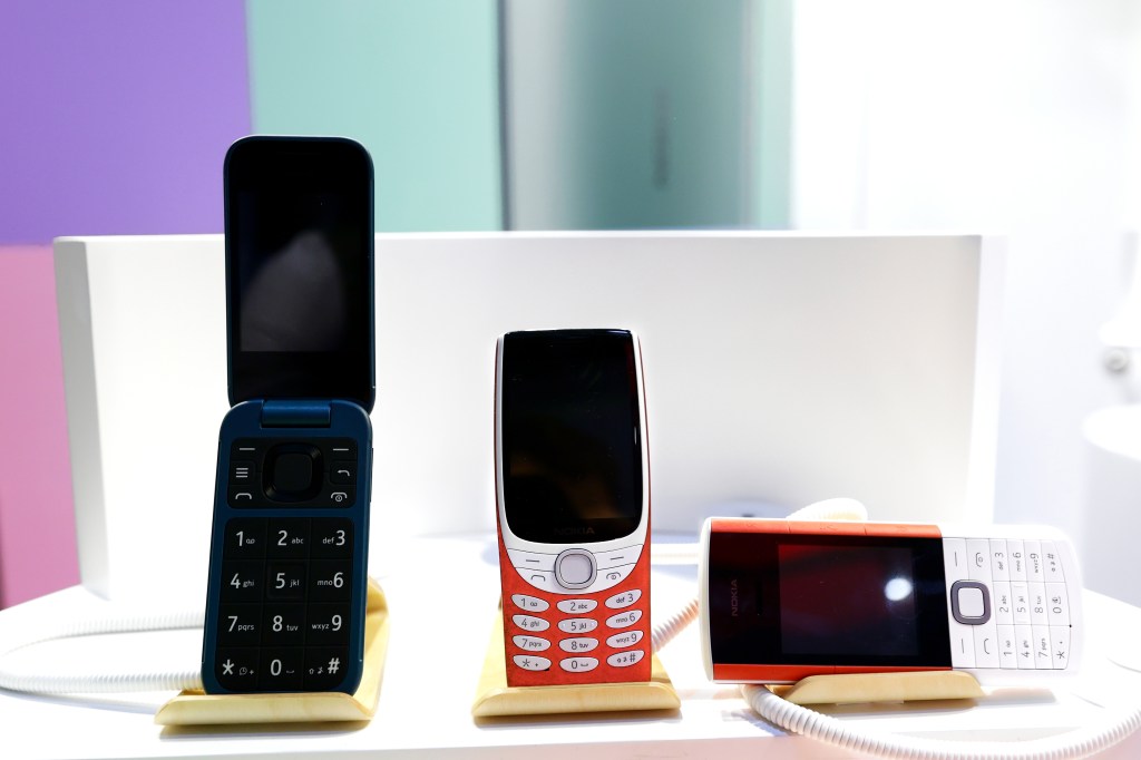 A Nokia 2660 Flip next to the Nokia 8210 and Nokia 5710 XA.