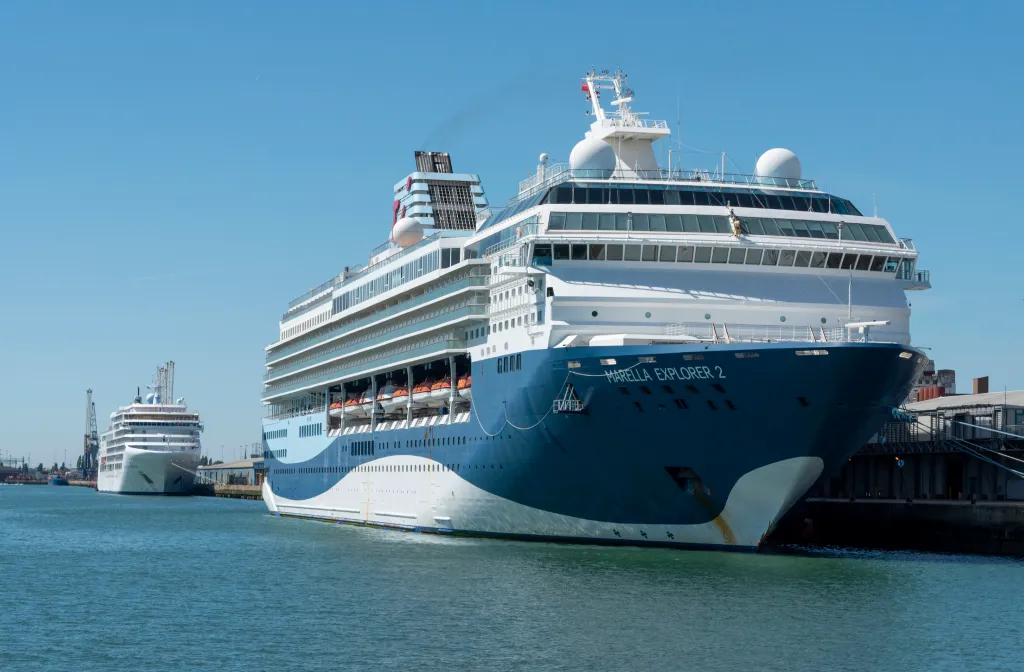 Cruise ship Marella Explorer 2 docked in a harbor, with another cruise ship in the background.