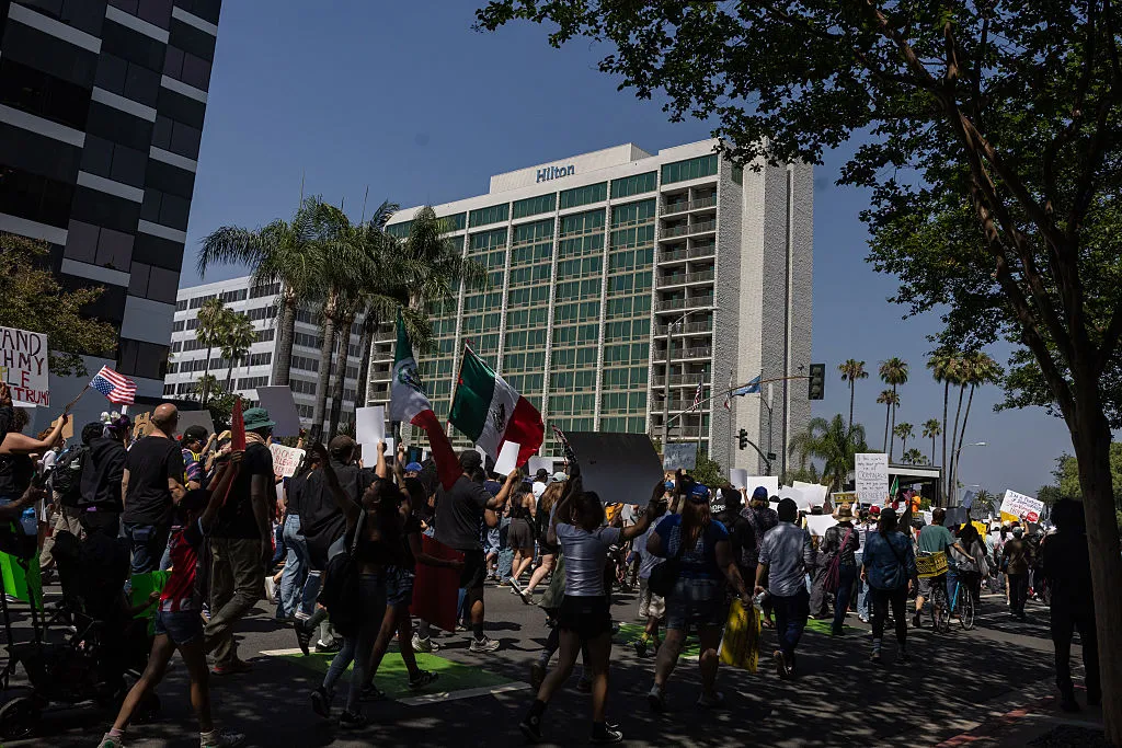 Community members take part in the Dena Protest that started a Pasadena City Hall and walked by four hotels, the Dena Hotel Pasadena, Hilton Pasadena, AC Hotel Pasadena, Westin Hotel Pasadena, in the area that housed ICE officials