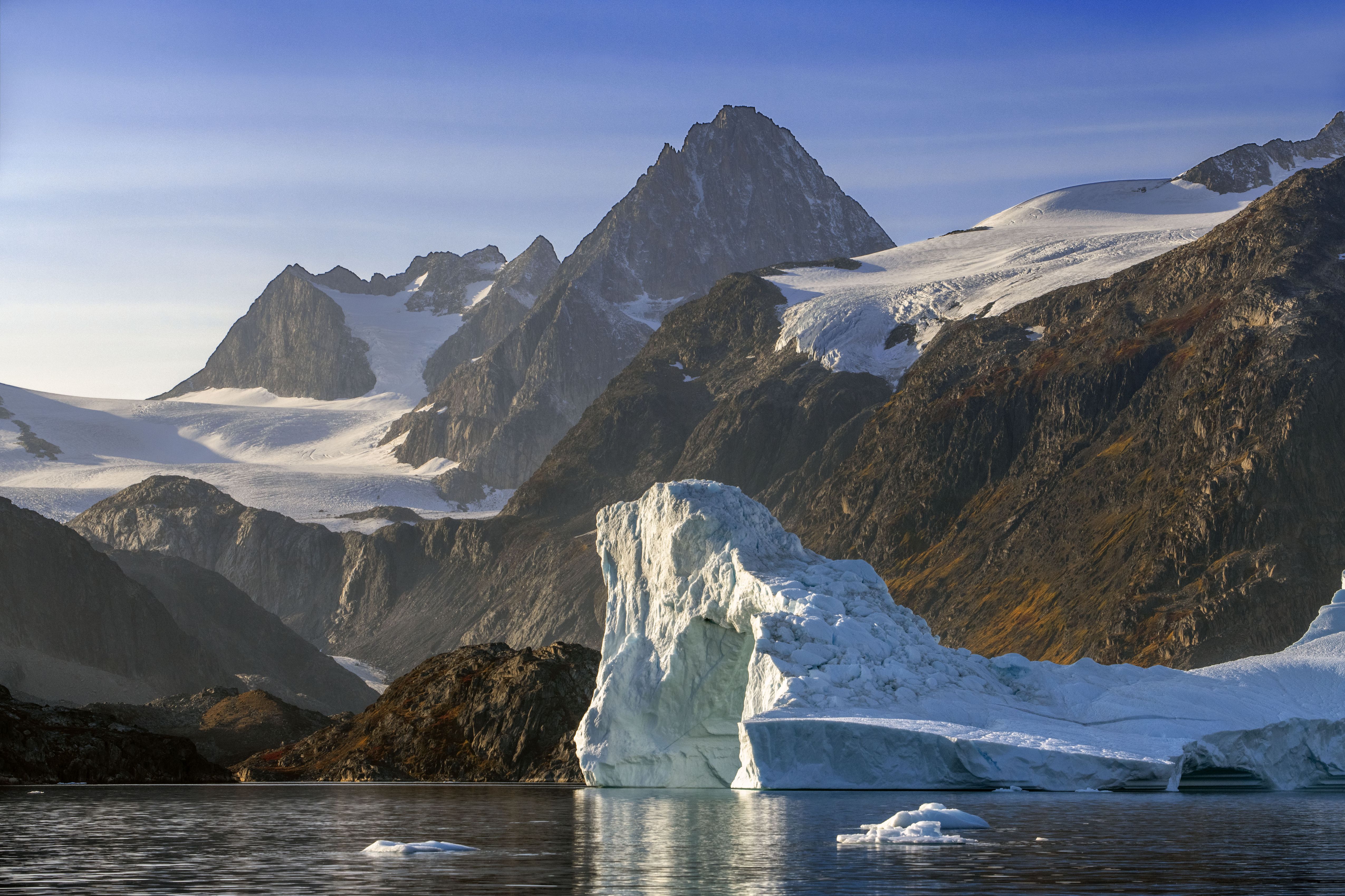 Skjoldungen Fjord, a large iceberg surrounded by snow-capped mountains, Southeast coast, Greenland. Skjoldungen Fjord, a large iceberg surrounded by snow-capped mountains, Southeast coast, Greenland.