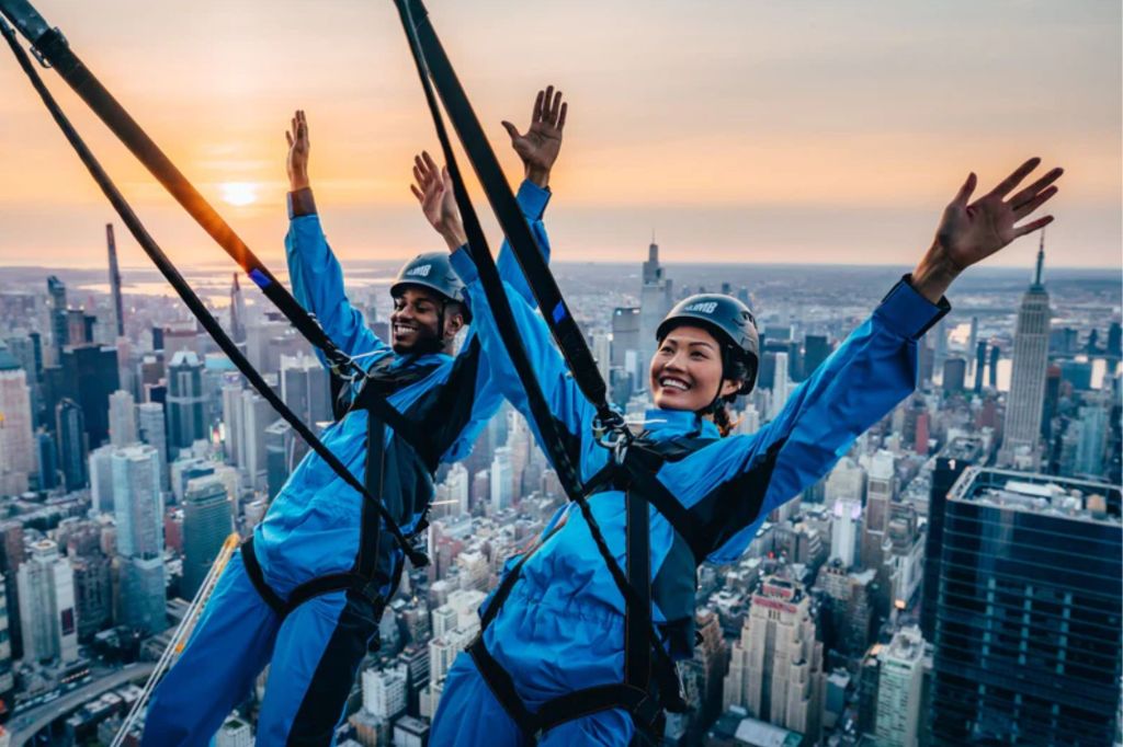 Two people propelling off a building.