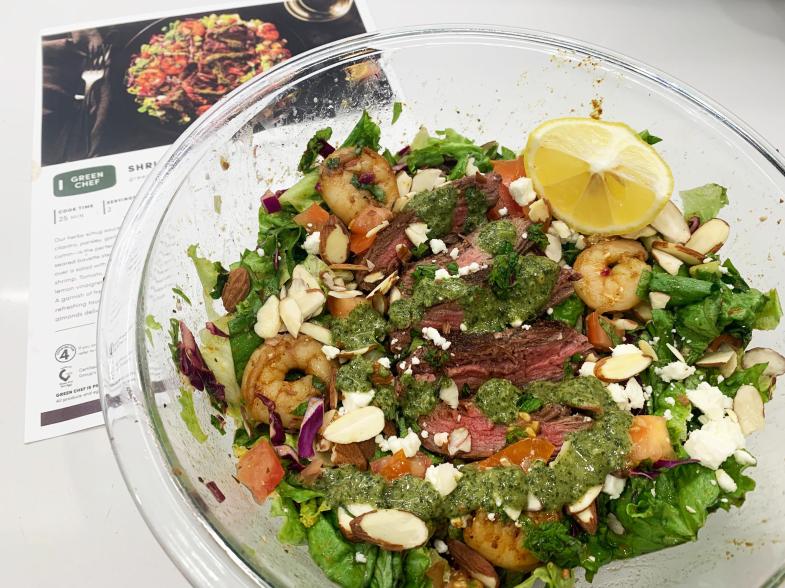 A salad next to a recipe card of that salad