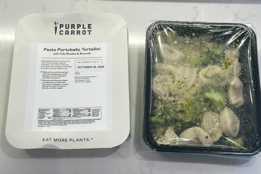 A tray of food covered with plastic wrap