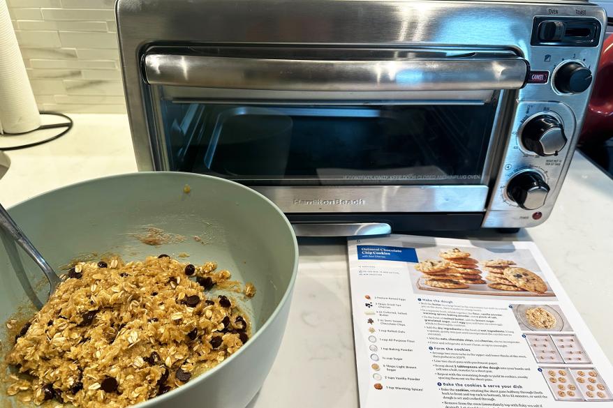 A bowl of cookies next to a toaster oven