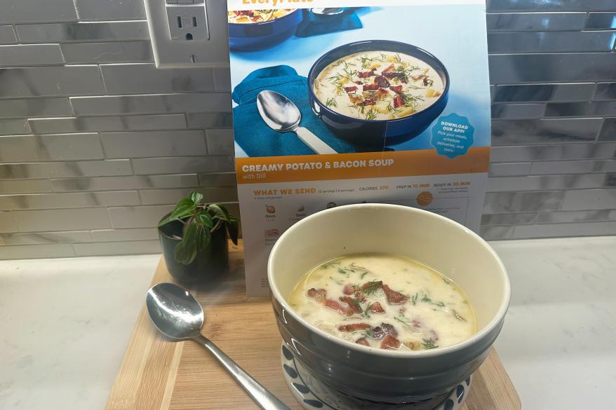 A bowl of soup next to its recipe card.