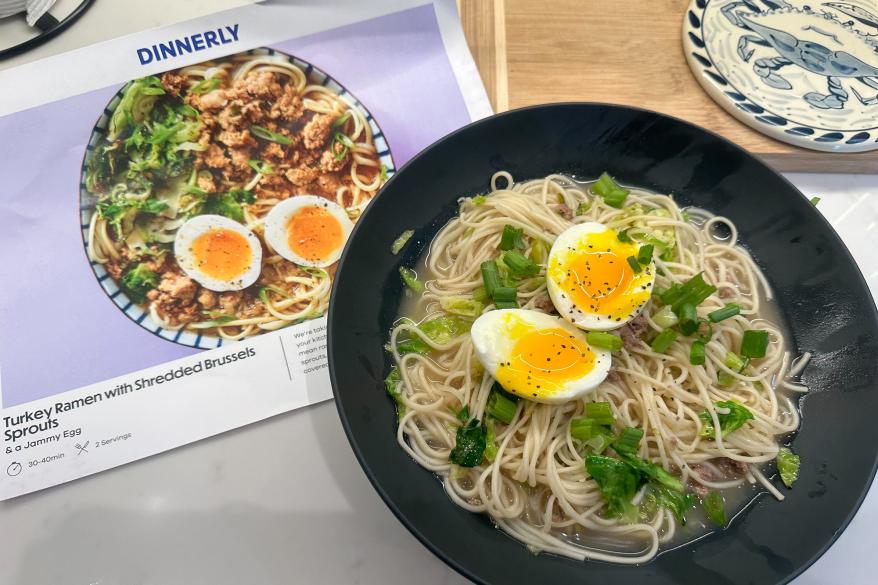 A bowl of noodles with eggs and green onions