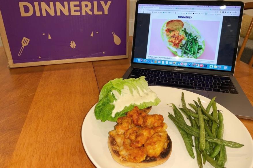 A plate of food next to a laptop